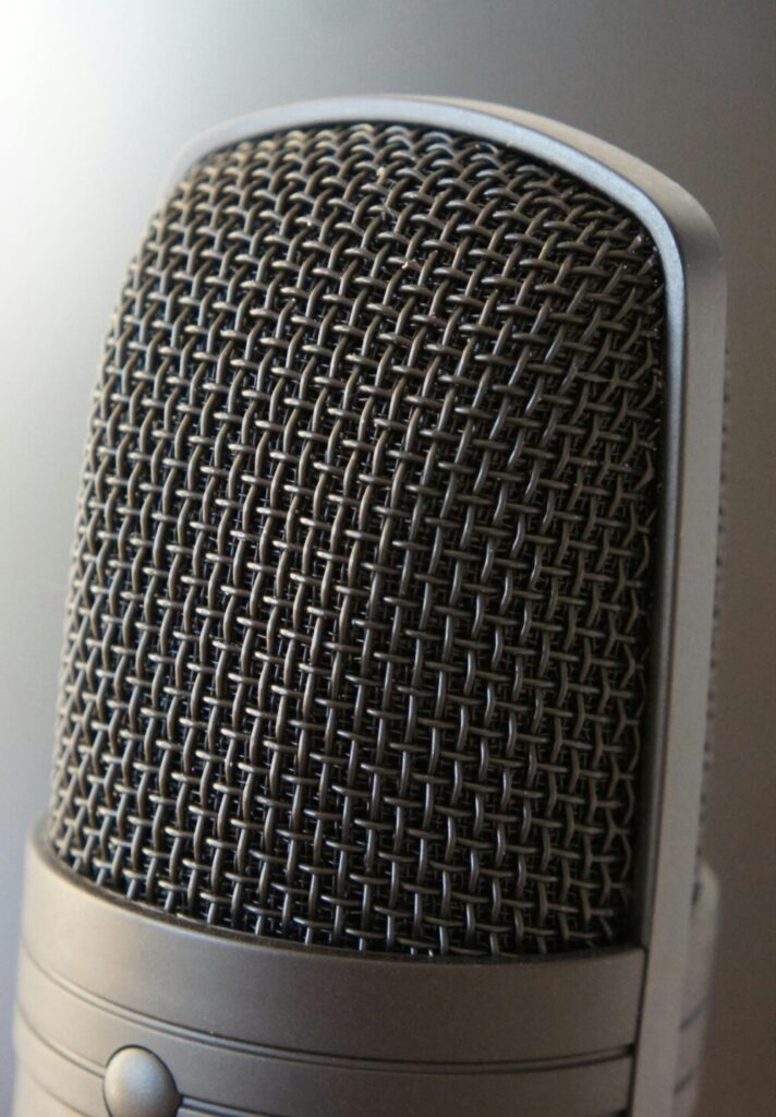 Detailed view of a professional condenser microphone with a blurred backdrop, ideal for audio equipment themes.