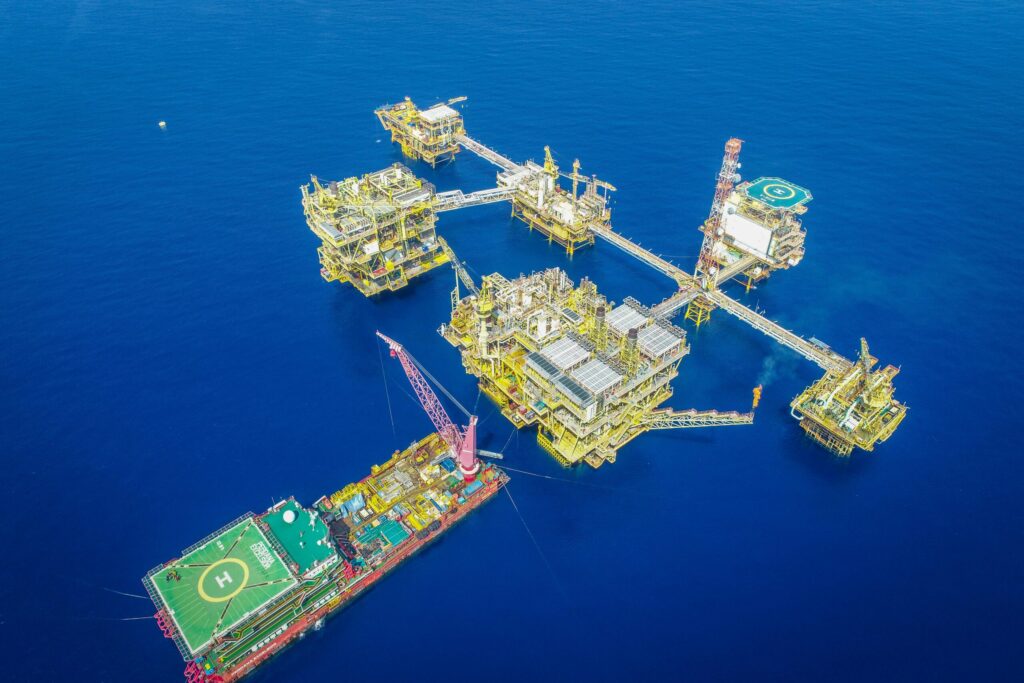 Aerial shot of an offshore oil platform complex in the ocean, showcasing industrial infrastructure.